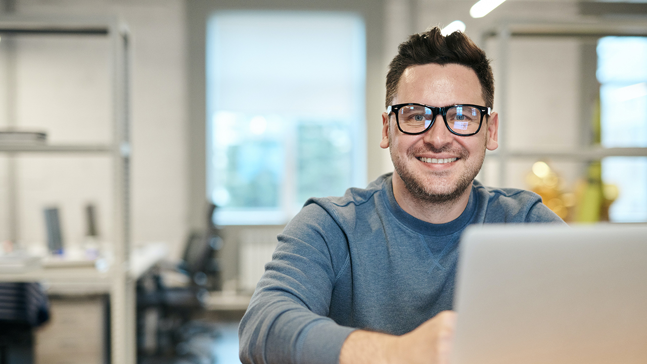 Man met bril achter computer