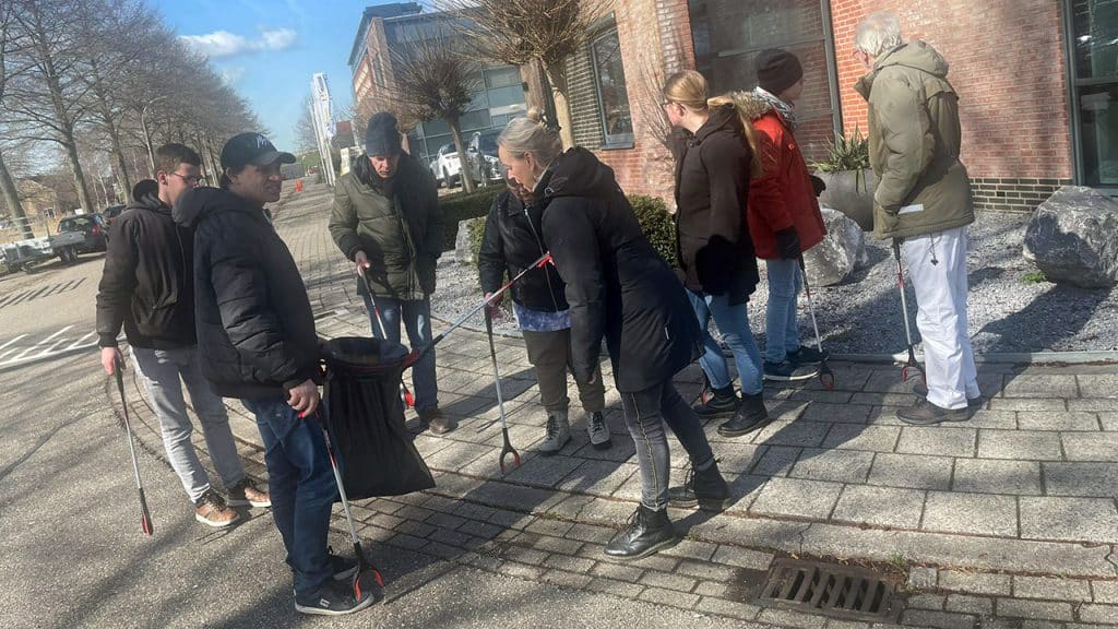 Petra Barnas raapt zwerfvuil met clienten van Bizzi op het bedrijventerrein Nieuweveen in Nootdorp